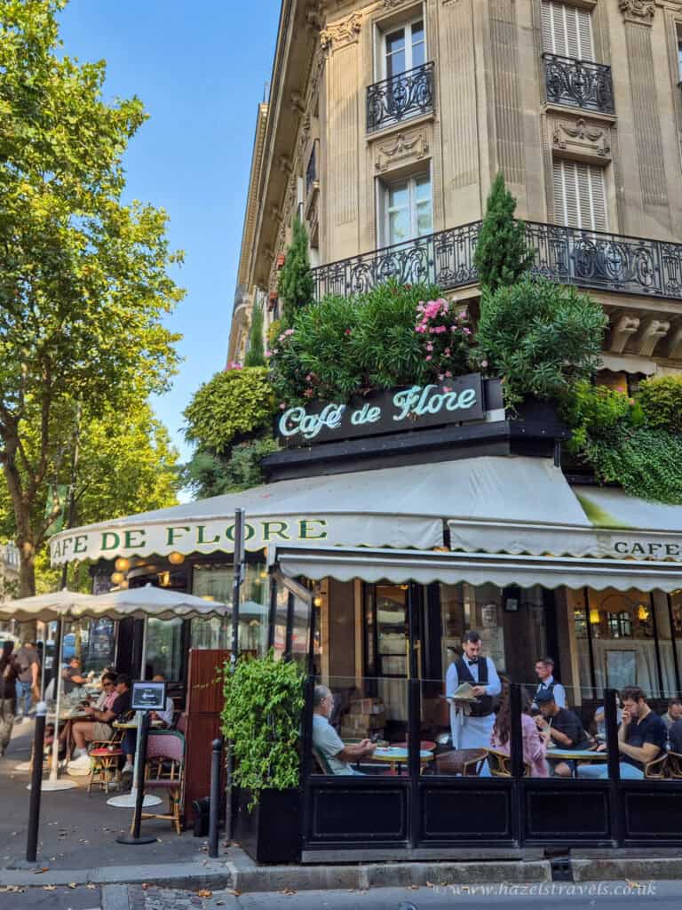 Café de Flore, Paris — Iconic Parisian café with flower-covered façade and outdoor seating on Boulevard Saint-Germain.