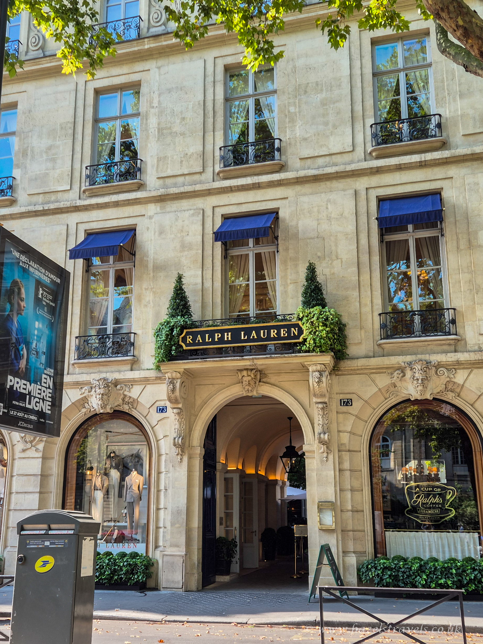 The elegant Ralph Lauren store in Saint-Germain-des-Prés, Paris, with classic cream stone architecture, blue awnings, and a grand arched entrance.