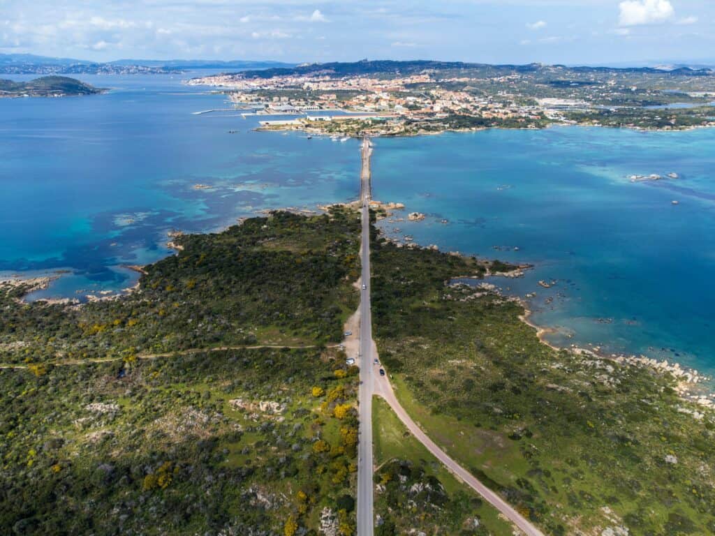 Aerial view of a road bridge in between two islands in Sardinia, Italy, Caprera Island and La Maddalena. Turquoise blue sea and green land.