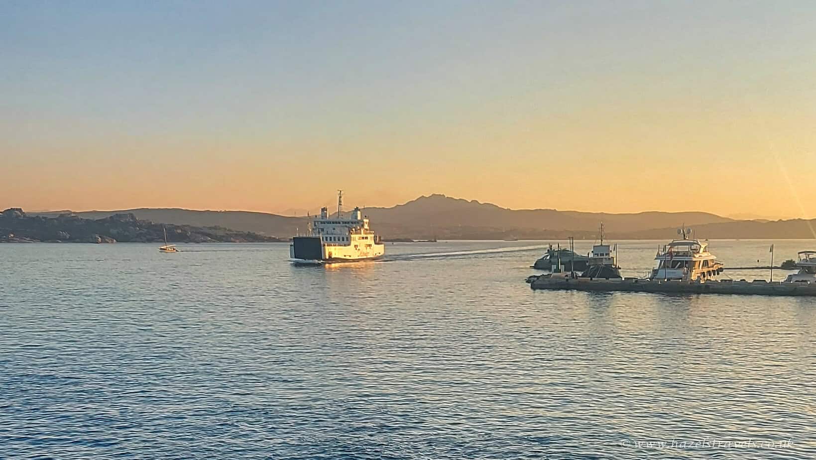 Boats in La Maddalena harbour at sunset - Ferries and yachts on calm evening waters with mountains in the distance.