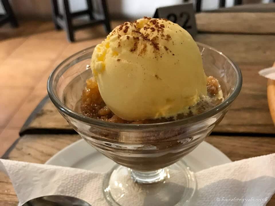 Glass dish of Bienmesabe, a Canarian dessert made with almonds, egg yolks, sugar, and lemon, topped with ice cream.