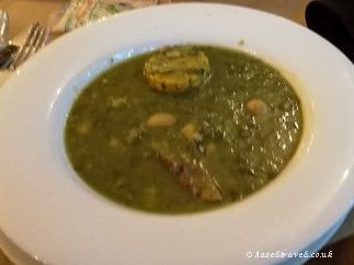Potaje de berros, a thick Canarian watercress soup with potatoes and corn, served in a white bowl.