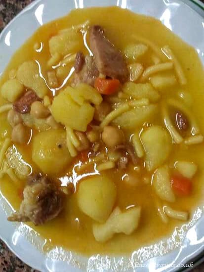 Bowl of Rancho Canario, a traditional Canary Islands stew with pasta, chickpeas, and meat in a rich broth.