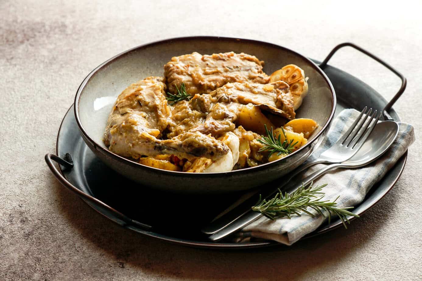 Pan of conejo en salmorejo, a Canarian rabbit stew cooked with garlic, paprika, and white wine.