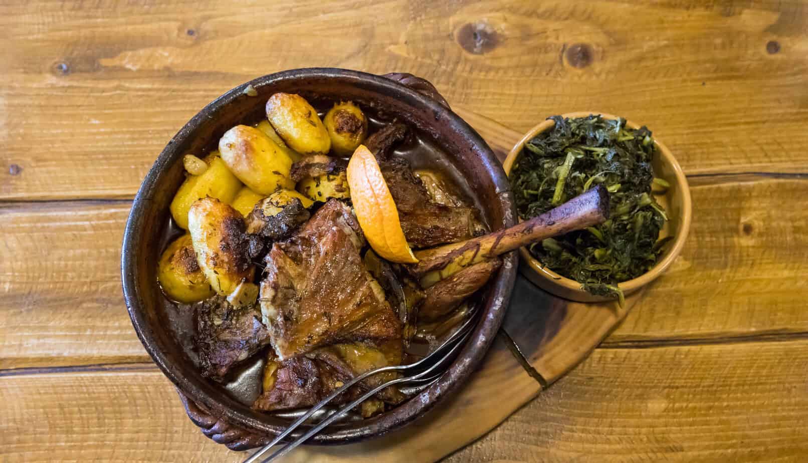 Plate of cabrito asado, roasted kid goat with potatoes and herbs, a traditional Canarian meal.