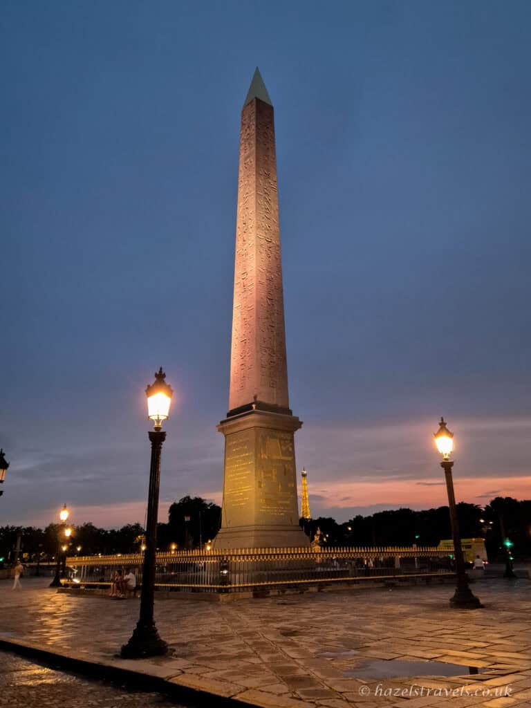 Obelisk at Place de la Concorde, Paris — The Luxor Obelisk lit by lampposts in the early evening.