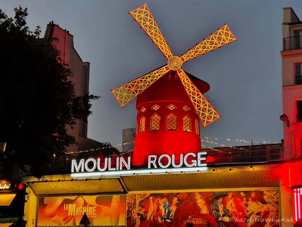 Moulin Rouge, Paris — Iconic red windmill of the Moulin Rouge cabaret glowing at night in Montmartre.