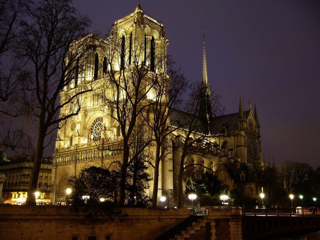Notre-Dame Cathedral at night, Paris — The illuminated façade of Notre-Dame standing out against the deep blue sky.