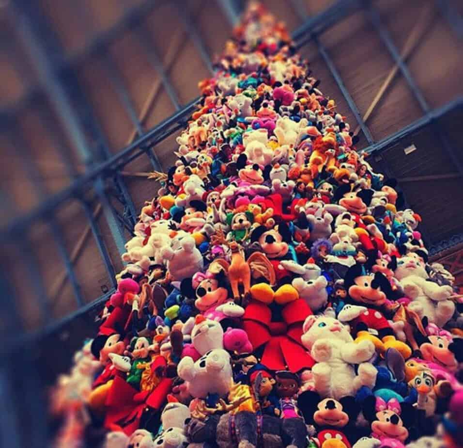 Close-up of St Pancras Christmas tree covered in multicoloured plush toys, including teddies and cartoon characters.