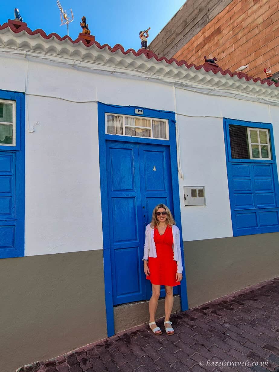 Traveller in a red dress standing beside a traditional blue-and-white house in La Palma’s old town.