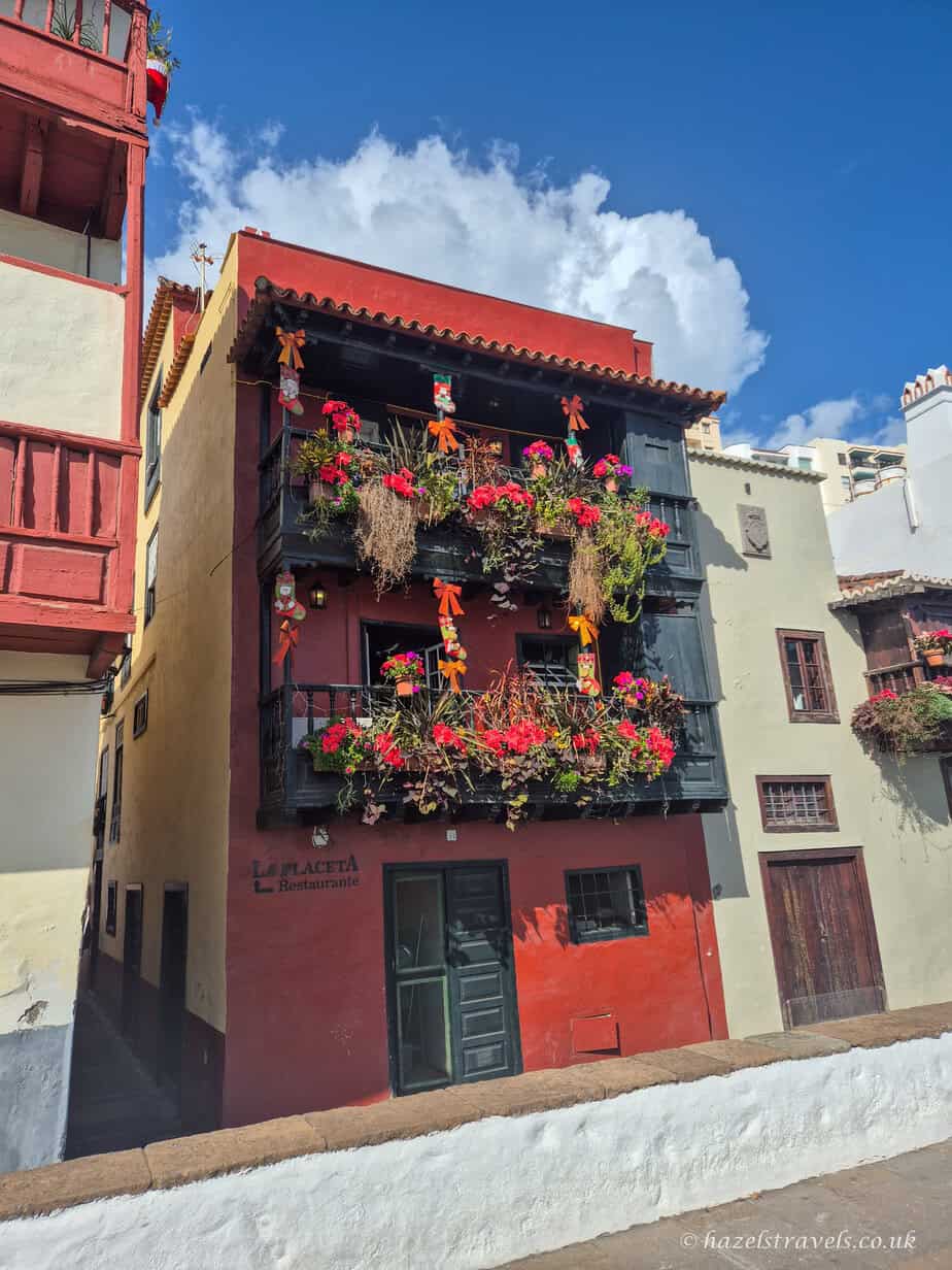 Traditional red house with wooden balconies and bright flower boxes in Santa Cruz de La Palma’s historic centre.