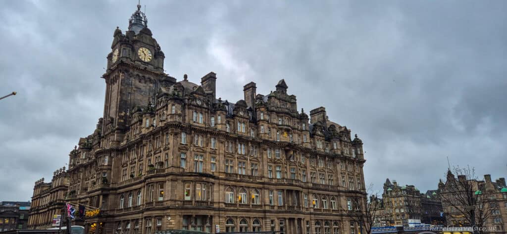 The Balmoral Hotel in Edinburgh with its iconic clock tower and grand Victorian façade under a cloudy sky