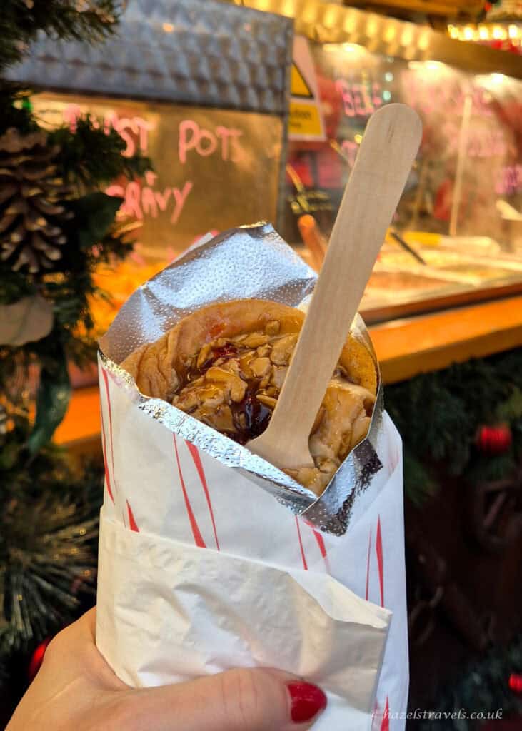 Roast turkey yorkshire pudding wrap with gravy and stuffing from the Edinburgh Christmas Market, served in a paper sleeve with a wooden fork