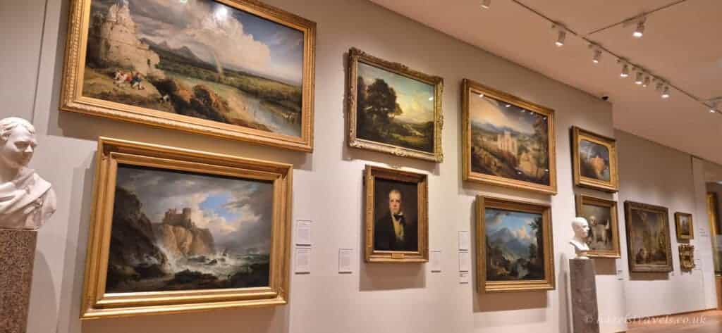 Gallery wall of framed landscape paintings and portraits inside the Scottish National Gallery in Edinburgh