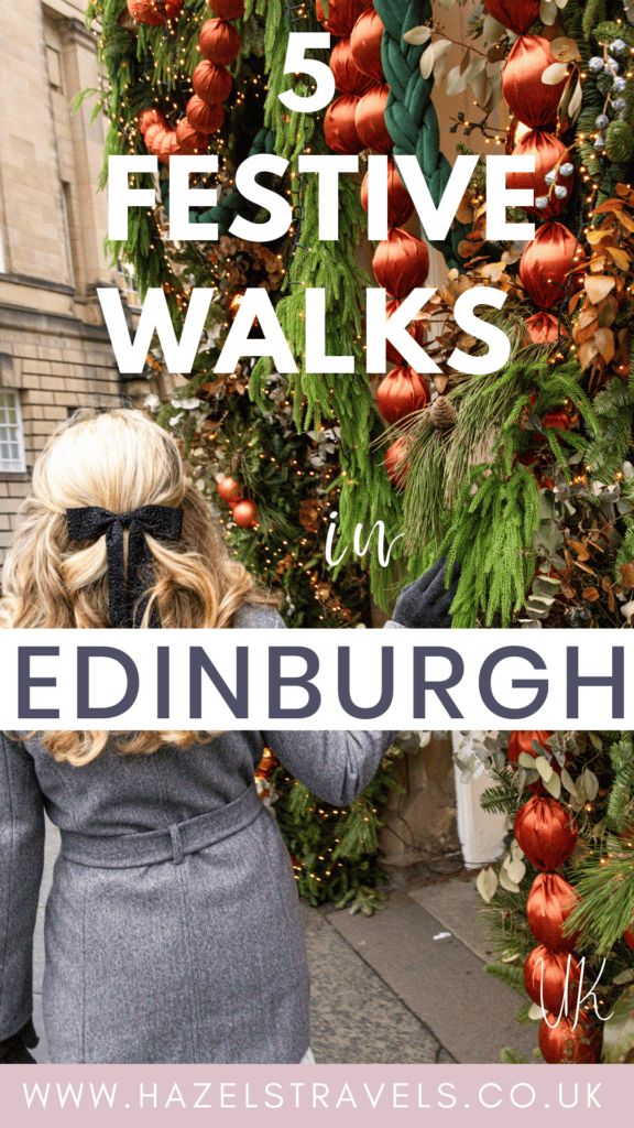 Woman in a grey winter coat walking past a festive garland covered doorway in Edinburgh, decorated with green foliage, red baubles and warm fairy lights, creating a cosy Christmas street scene in soft seasonal colours
