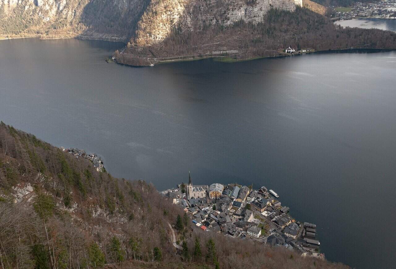 Aerial view of Hallstatt village and church from the Hallstatt Skywalk above a grey Lake Hallstatt in winter