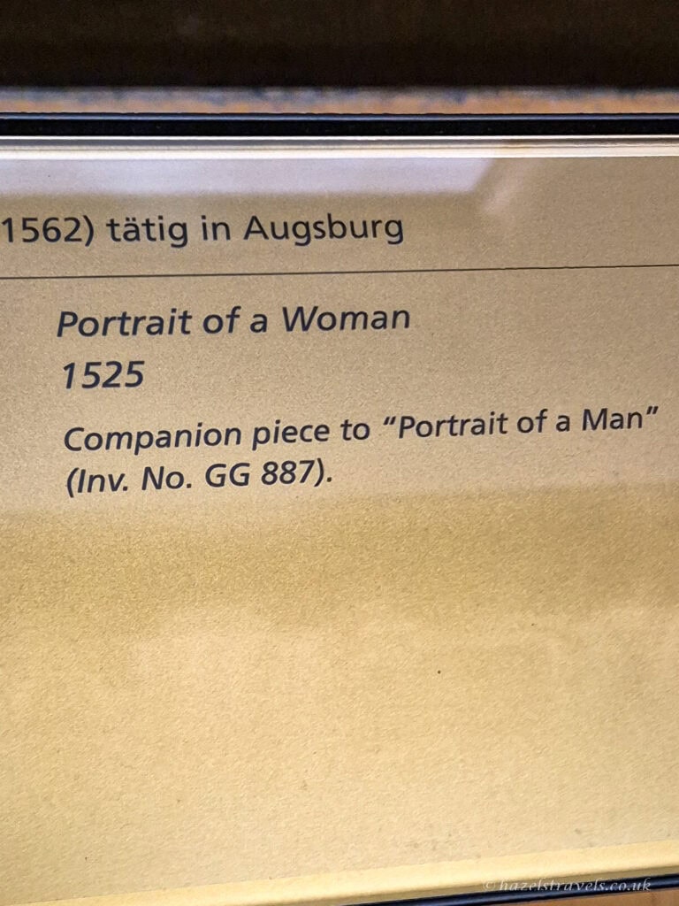 Museum label for “Portrait of a Woman” (1525), noted as the companion piece to “Portrait of a Man” at the Kunsthistorisches Museum.