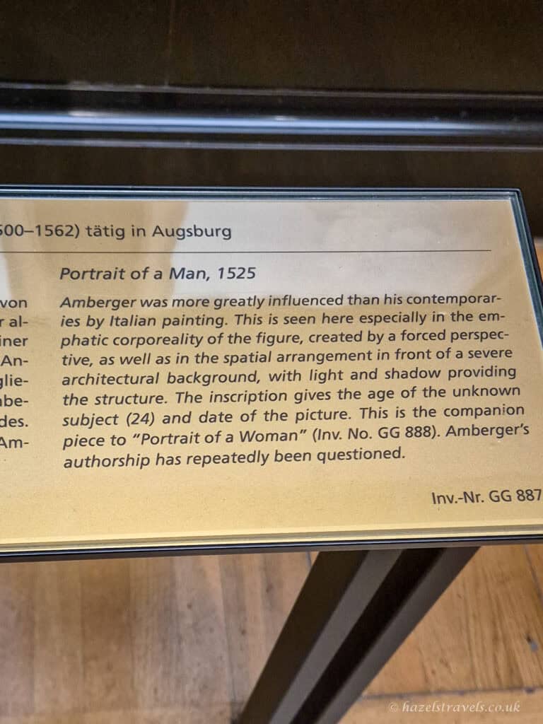 Museum information plaque for “Portrait of a Man” (1525) attributed to Amberger, noting it as the companion to “Portrait of a Woman”.