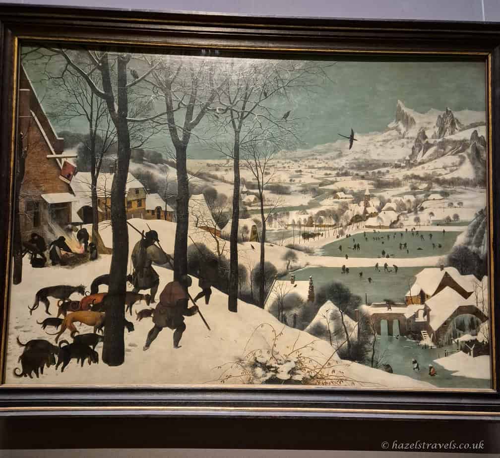 Pieter Bruegel the Elder’s painting “Hunters in the Snow”, showing hunters and dogs returning through a snowy village landscape.